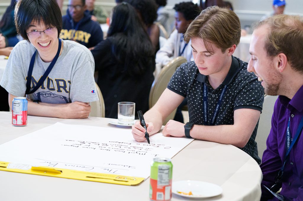 Students writing together at a table.