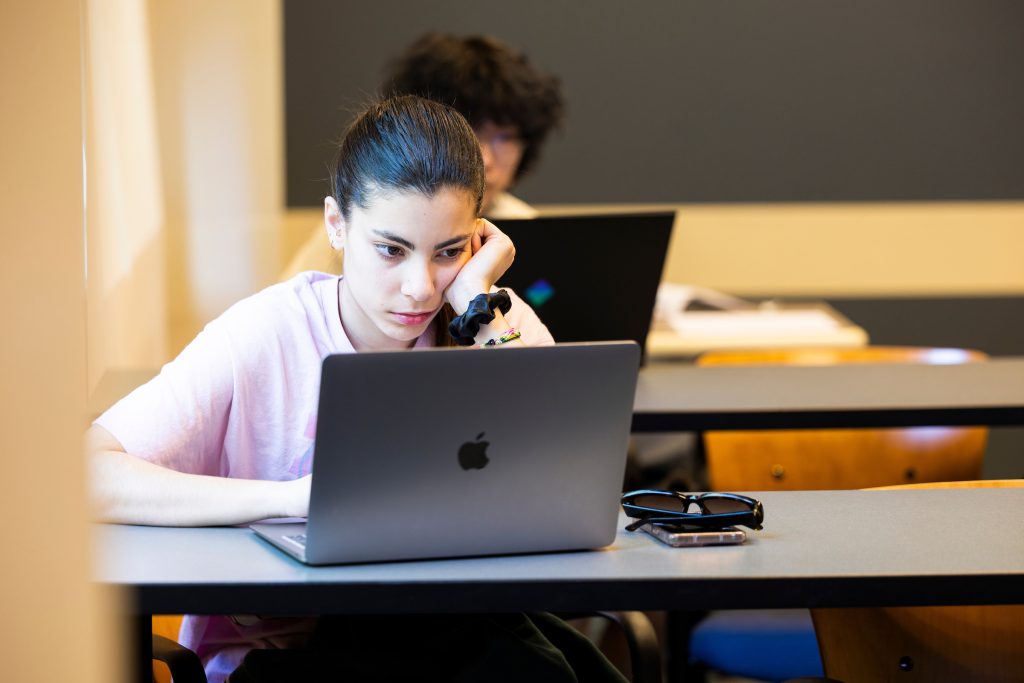 Female student works on her laptop during a class at Emory University.